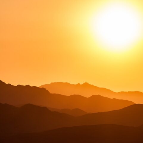 silhouette of mountains under orange sky